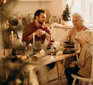 Family at table for Christmas Dinner during holidays with grandma and son and grandkids