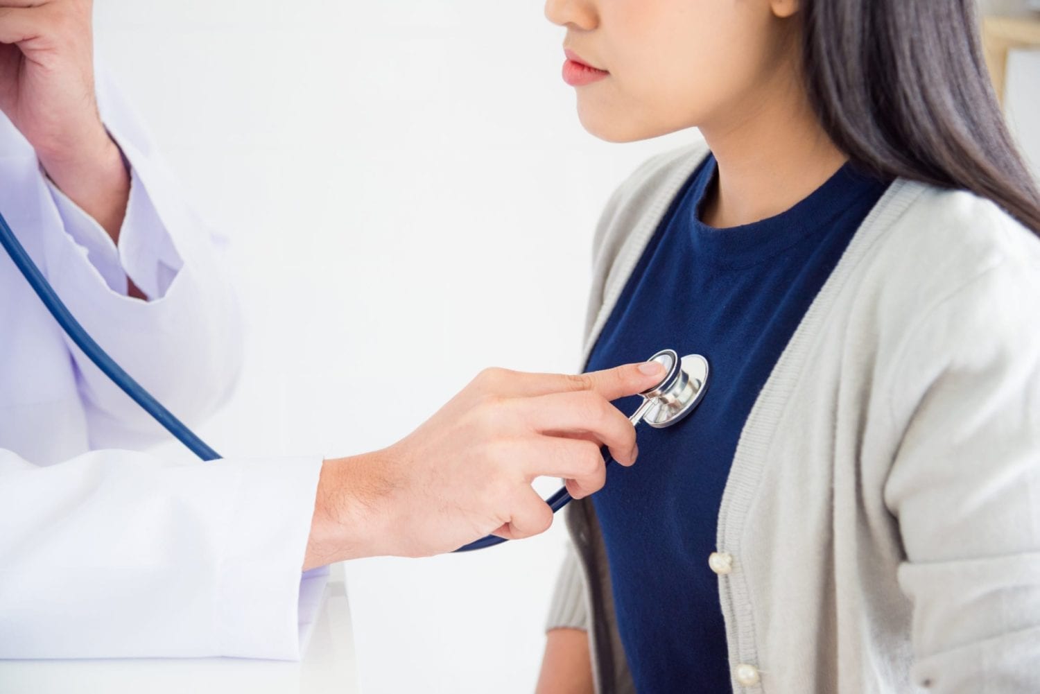 Doctor checking patient's heartbeat by stethoscope at hospital; highlighting the link between heart health and low white blood cell count