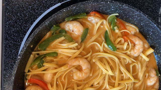 Close up of Red Thai Curry recipe with shrimp in a black bowl.