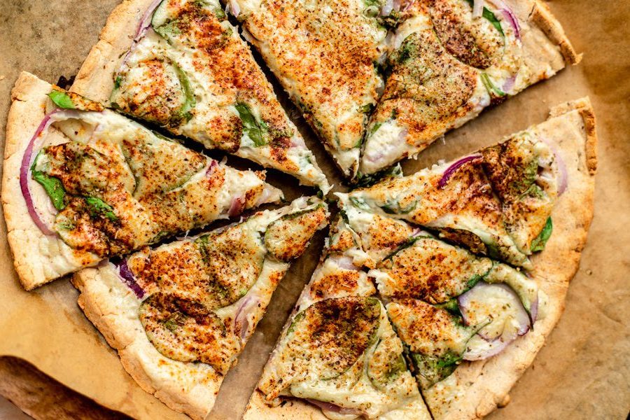gluten free pizza top down view, with toppings on a brown surface