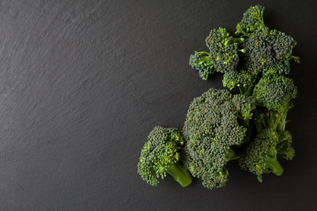 Cut broccoli florets on a grey background, ready to make your Cranberry Almond Broccoli Salad.